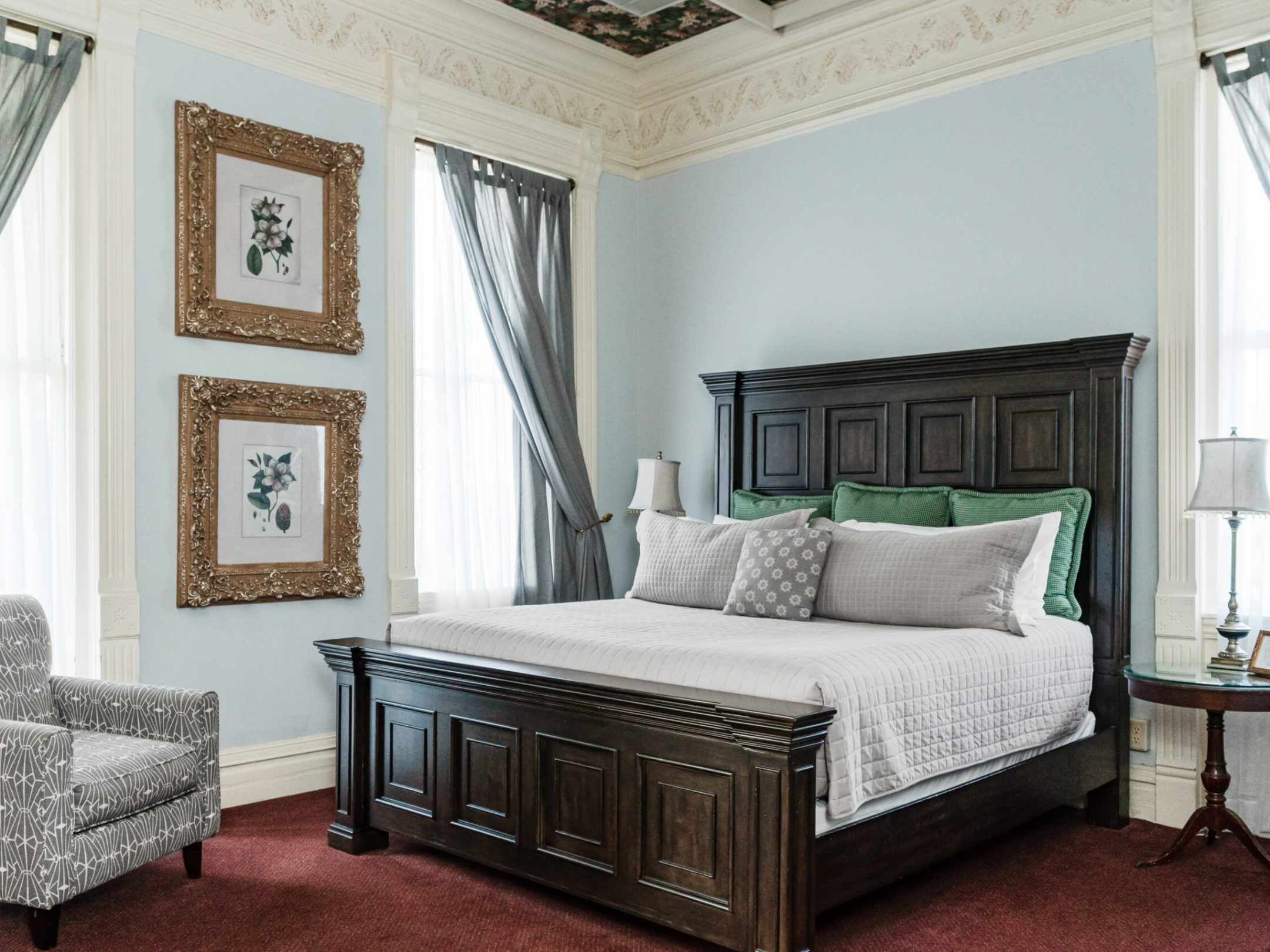 a bedroom with a bed and a chair in a room