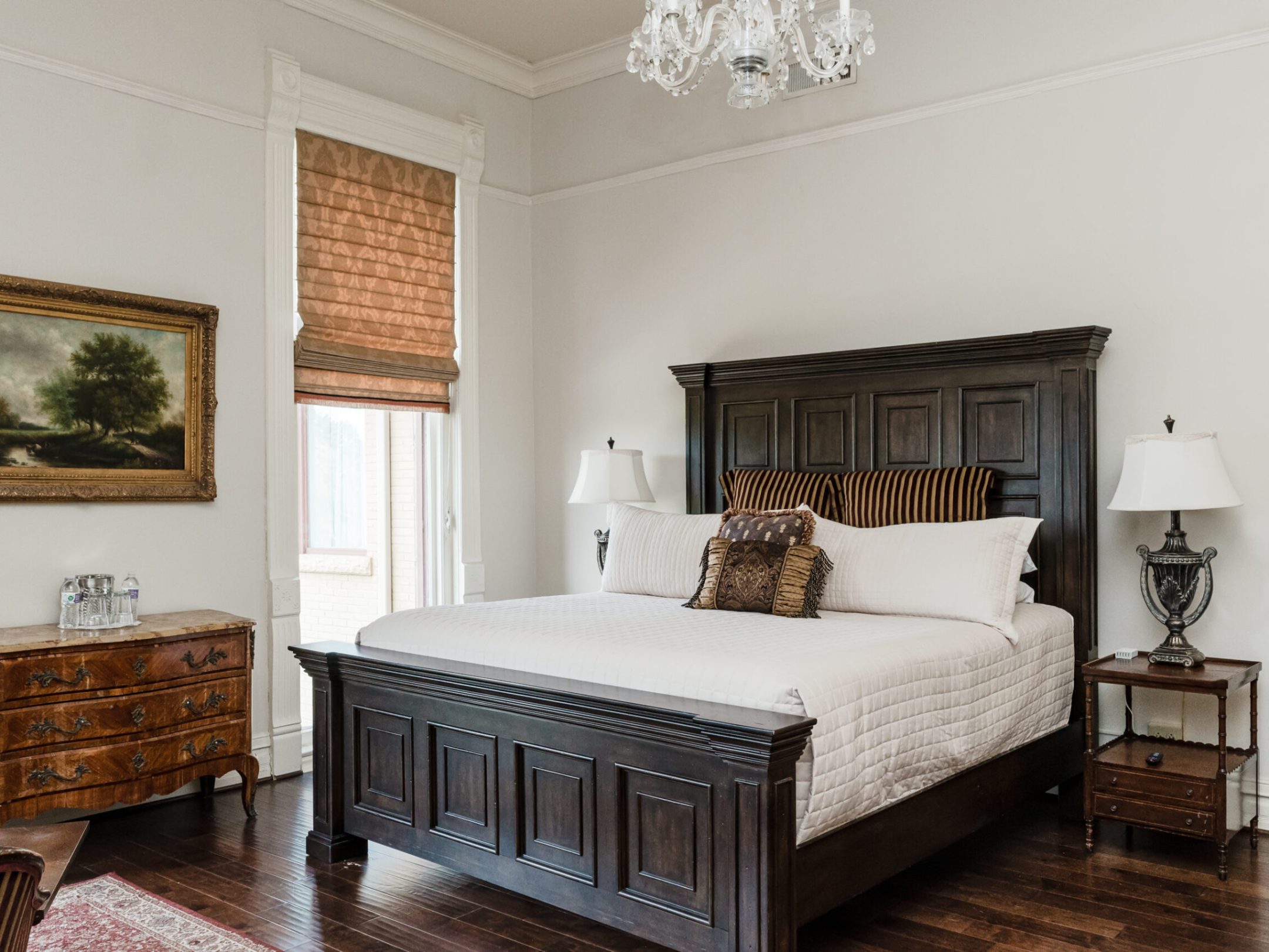 a bedroom with a bed and a chair in a room