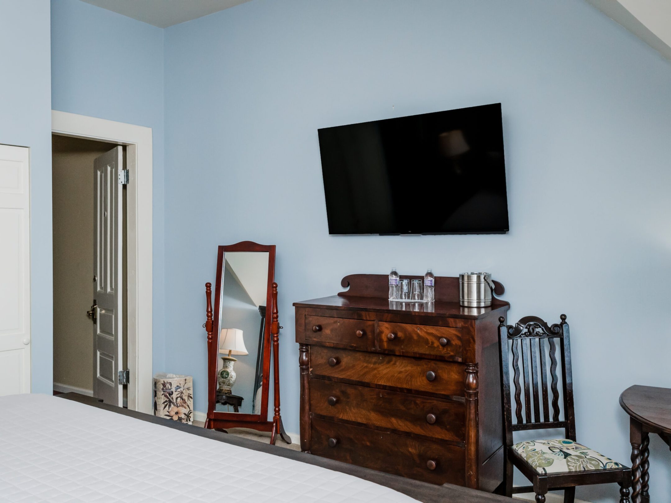 a bedroom with a bed and a chair in a room