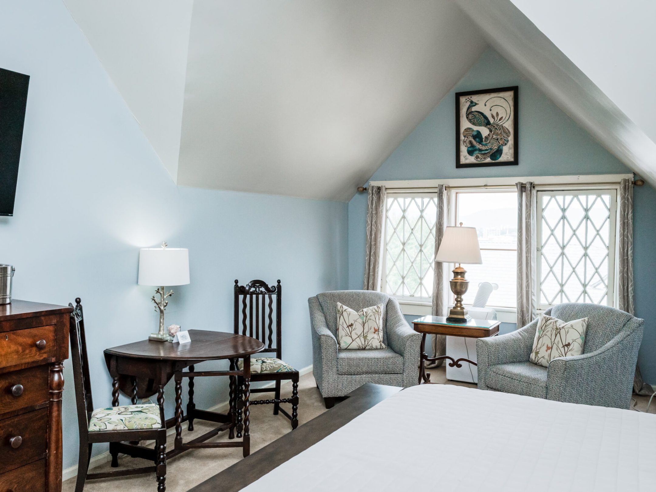 a bedroom with a bed and a chair in a room