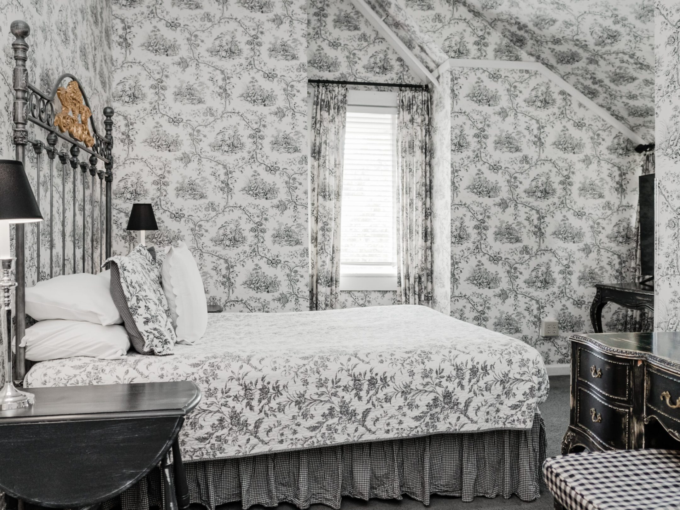 a bedroom with a bed and a chair in a room