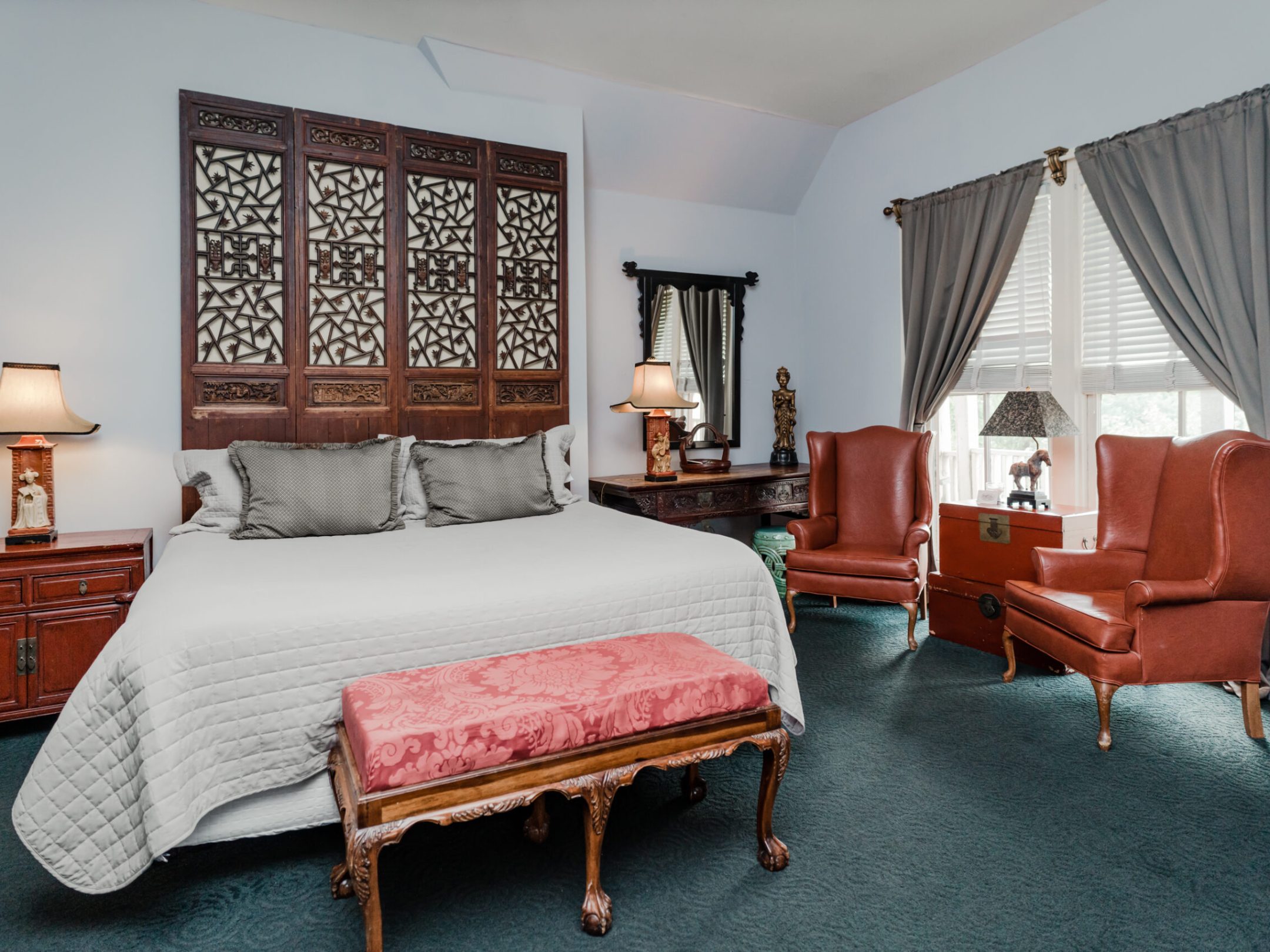 a bedroom with a bed and a chair in a room