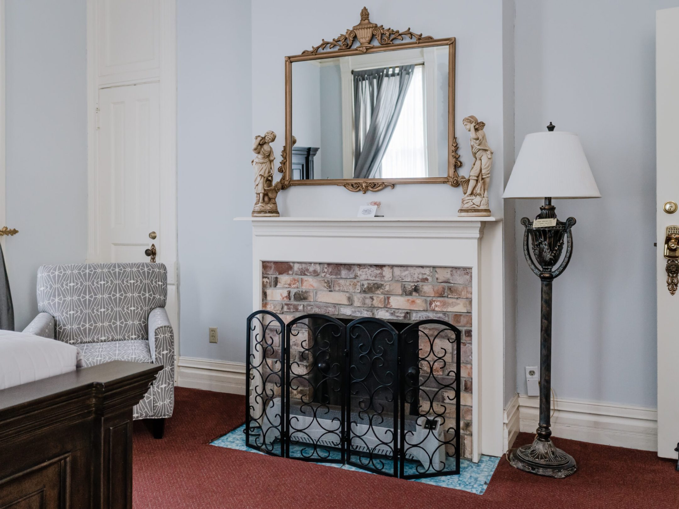 a bedroom with a bed and a mirror in a room
