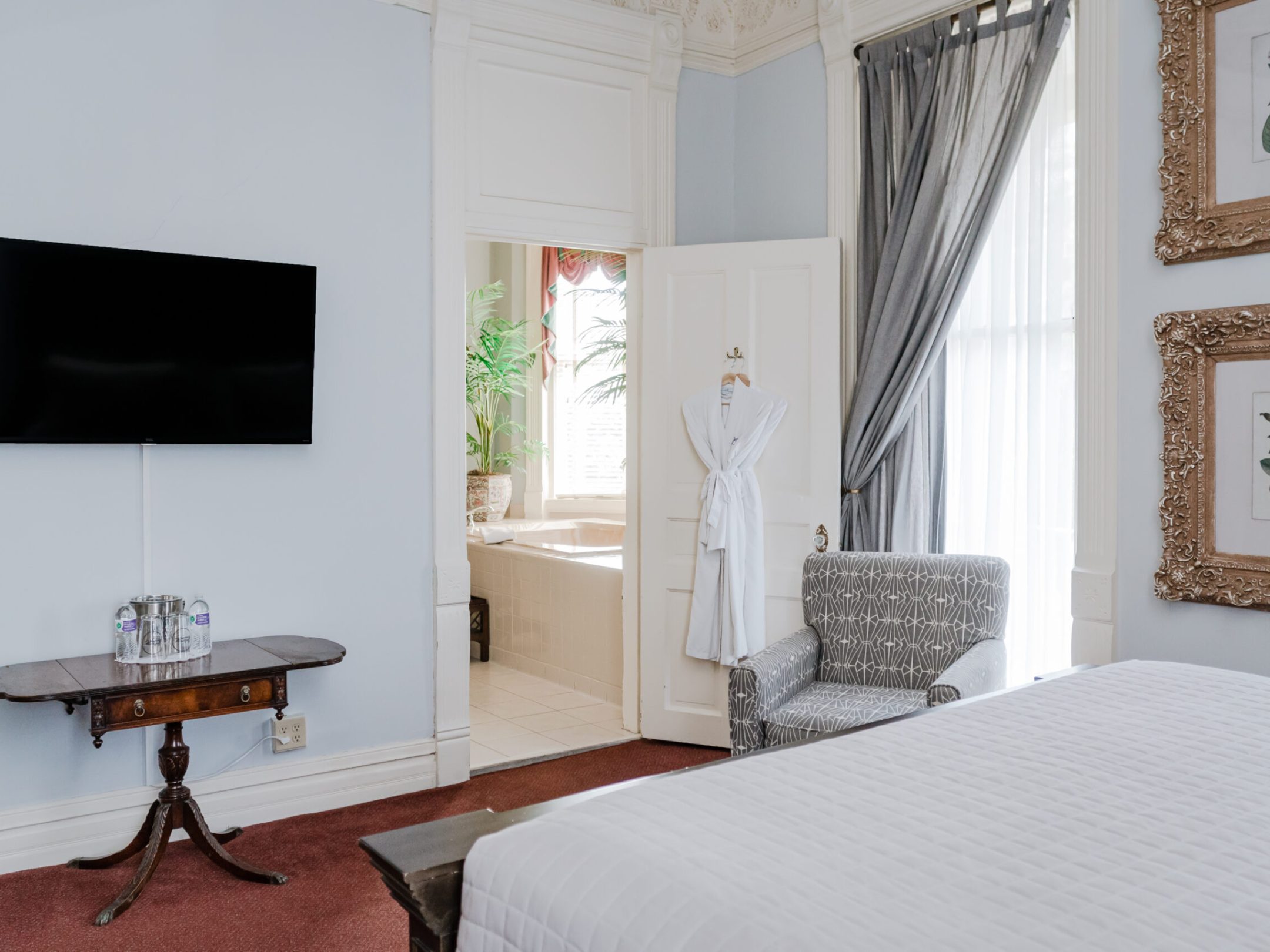 a bedroom with a bed and a mirror in a room