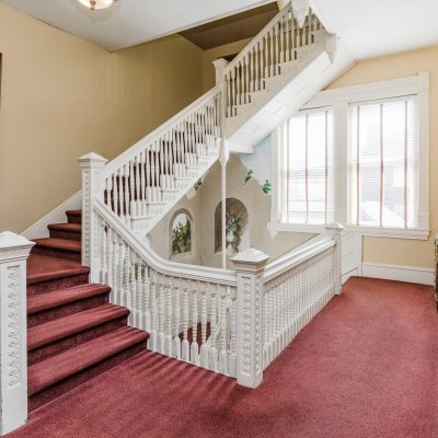 a bedroom with a bed and a chair in a room
