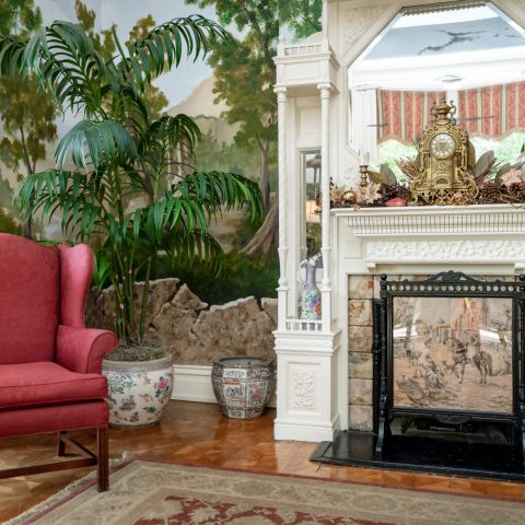 a fire place sitting in a living room with a christmas tree
