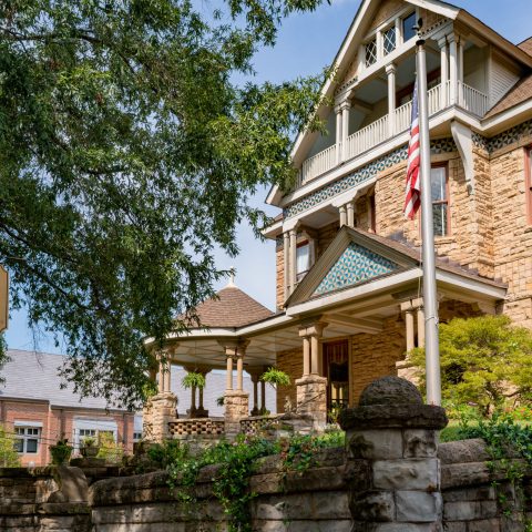 a large brick building with a clock on the front of a house