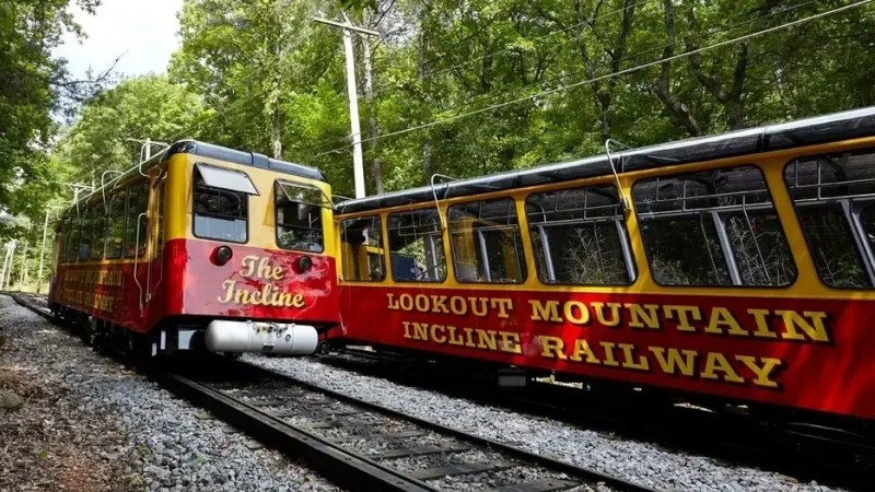 Red and yellow train labeled 'Lookout Mountain Incline Railway' on forested track.