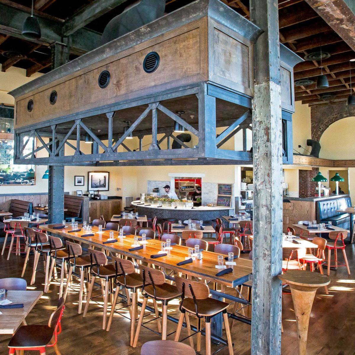 Spacious restaurant with wooden tables, chairs, and exposed beams.